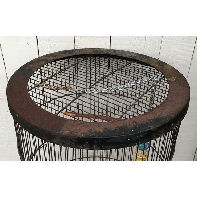 Antique metal bird cage from the early 20th century. One opening. Perch inside. Measurements 15” Width 36” Height...