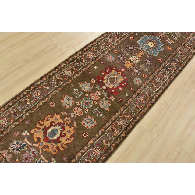 A traditional tribal Caucasian Kazak runner hand-knotted with fine wool on a cotton foundation. This rug features a row of...