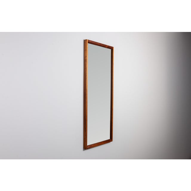 This Mid-Century solid rosewood No. 145 mirror by Kai Kristiansen, designed for Aksel Kjersgaard in Odder, Denmark, is a...