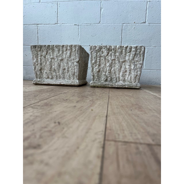 A handsome pair of vintage faux bois planters featuring a richly textured bark-like surface in weathered cast concrete or...