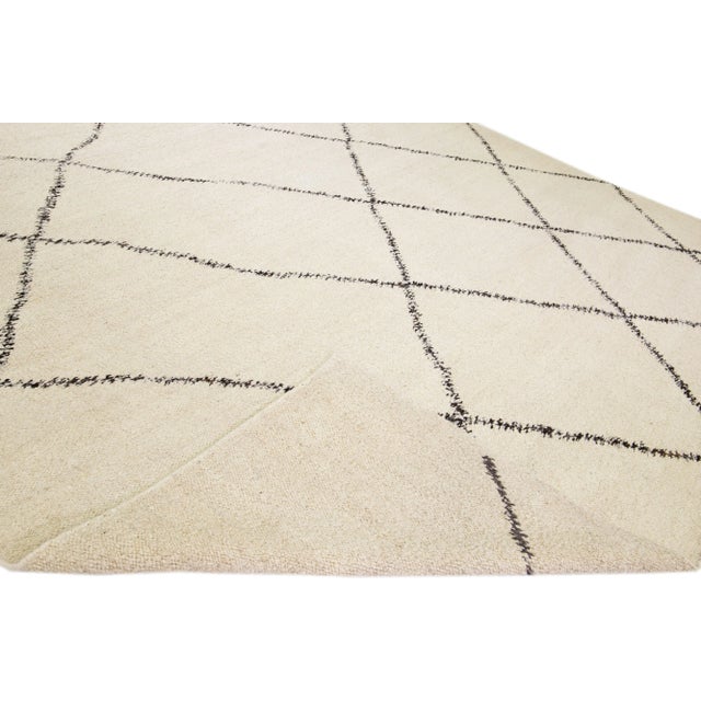 Beautiful modern Moroccan style hand-knotted wool rug with an ivory field. This piece has dark brown accent color in a...