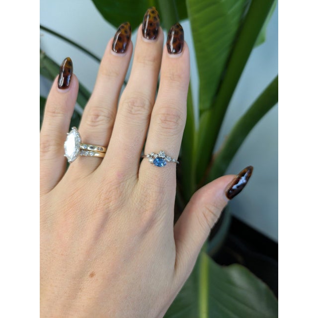 A 0.67-carat blue montana sapphire oval sits at the centre of this solid 14K white gold ring, framed by eight earth-mined...