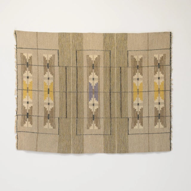 Mid-Century Swedish kilim in neutral tones with a hint of yellow and purple. Fine quality wool in a geometric pattern....
