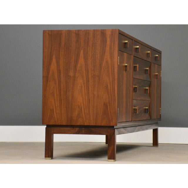 A mid century modern walnut sideboard credenza with two doors and six drawers designed by Edward Wormley for Dunbar....