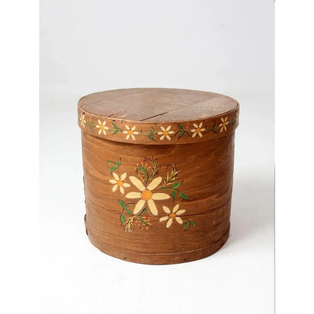 A charming rustic storage piece featuring a hand painted yellow floral motif with green accents. The simple form and aged...