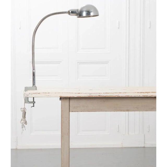This vintage desk lamp attaches to your tabletop with a self cranking clamp, and the gooseneck articulation is very sturdy...