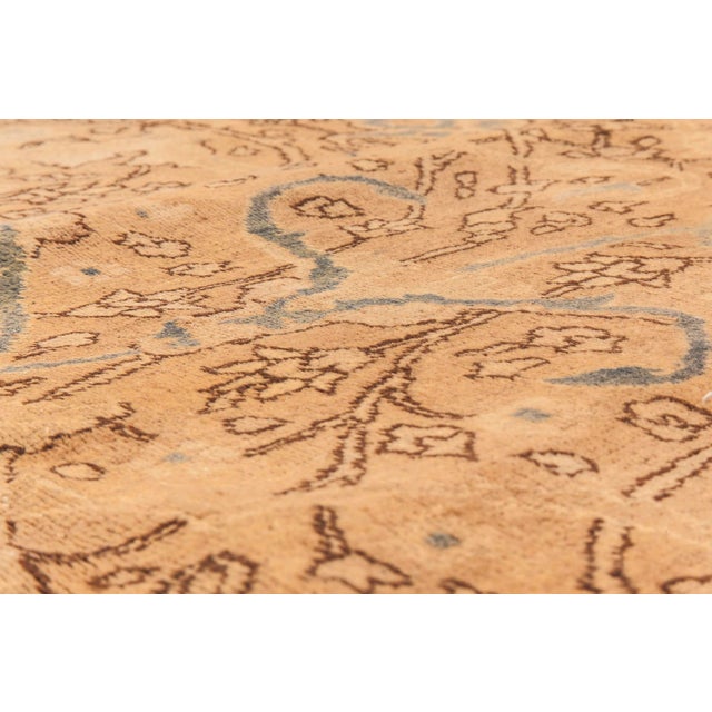 An early 20th century antique Persian rug patterns, the abrashed light brown field with an allover trellis of vinery and...