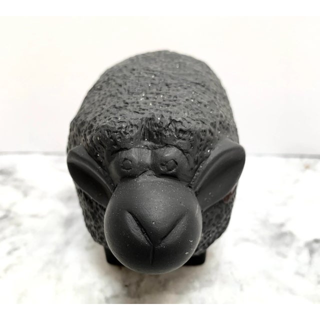 Whimsical solid stone like decor figure of a black sheep. Tiny flecks of white show in the black textured coat and a funny...