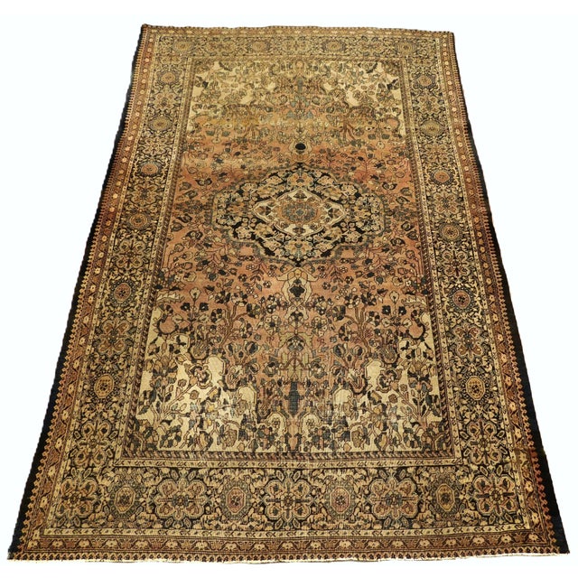 This antique hand-knotted Persian area rug features an intricate central medallion, detailed floral and vine (arabesque)...