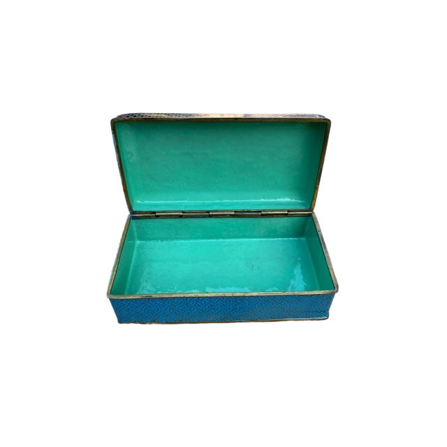 This a beautiful Chinese cloisonné box featuring a vivid turquoise enamel exterior adorned with three colorful...