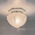 Art deco ceiling light in white glazed porcelain with a globe of partially matte sandblasted glass featuring stepped...