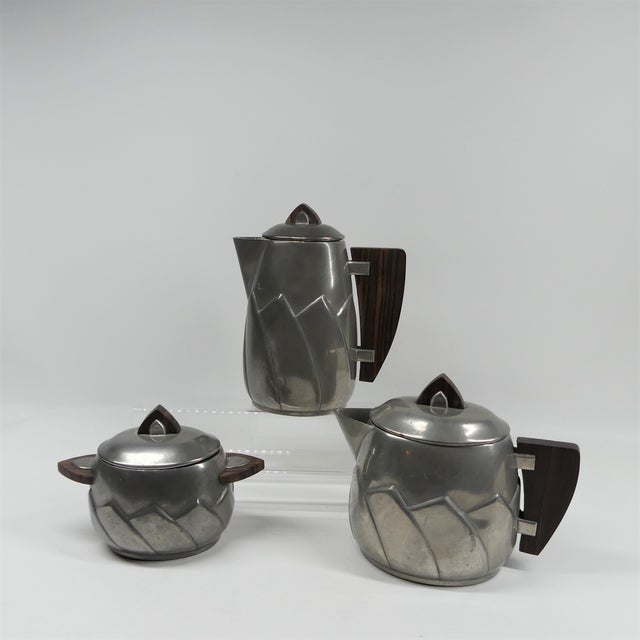 Extremely rare set, consisting of a coffee pot, teapot and pewter made of tin with wooden handles. It is a French Art Deco...