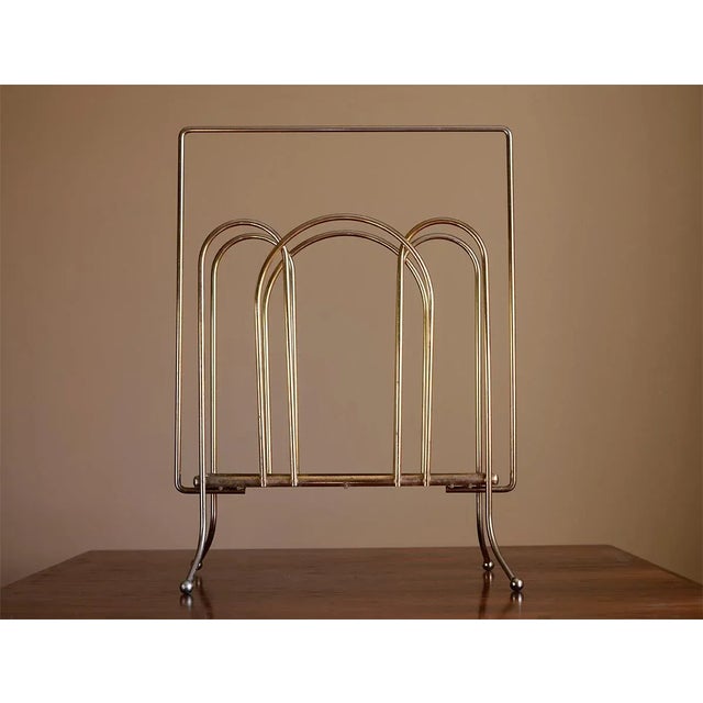 A real modernist stunner from the 1950s! This tall, minimal and elegant magazine rack is made of almost entirely brass...