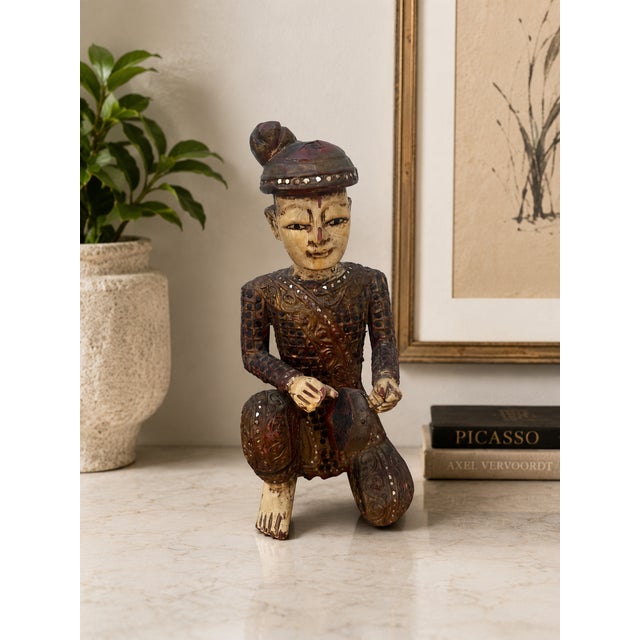Hand-carved Chinese wooden figural sculpture depicting a seated musician holding a tambourine-style percussion instrument....
