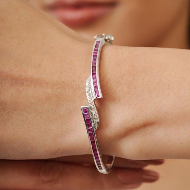 Stylish vintage bangle crafted in 925 sterling silver, featuring vibrant ruby gemstones accented with sparkling diamonds...