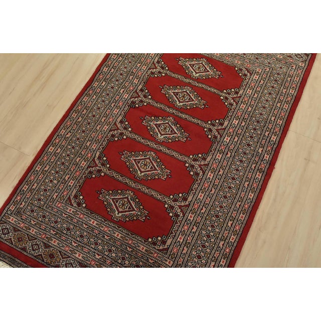 A tribal Bokhara Jaldar rug hand-knotted with fine wool on a cotton foundation. This rug features geometric medallions set...