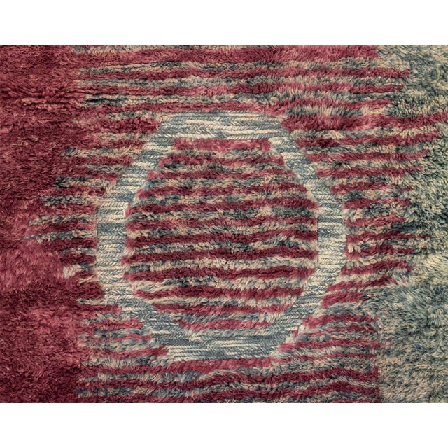 Luxurious hand-knotted wool rug, blending rich Red Wine, Ocean Teal, and Arctic teal with a subtle transition, adorned...