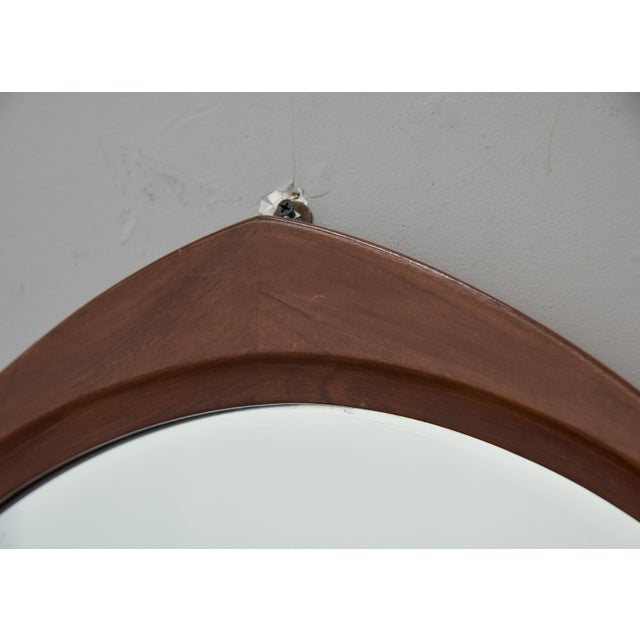 A striking Italian Mid-Century wall mirror featuring a sculptural rounded trefoil frame in warm walnut with a refined...