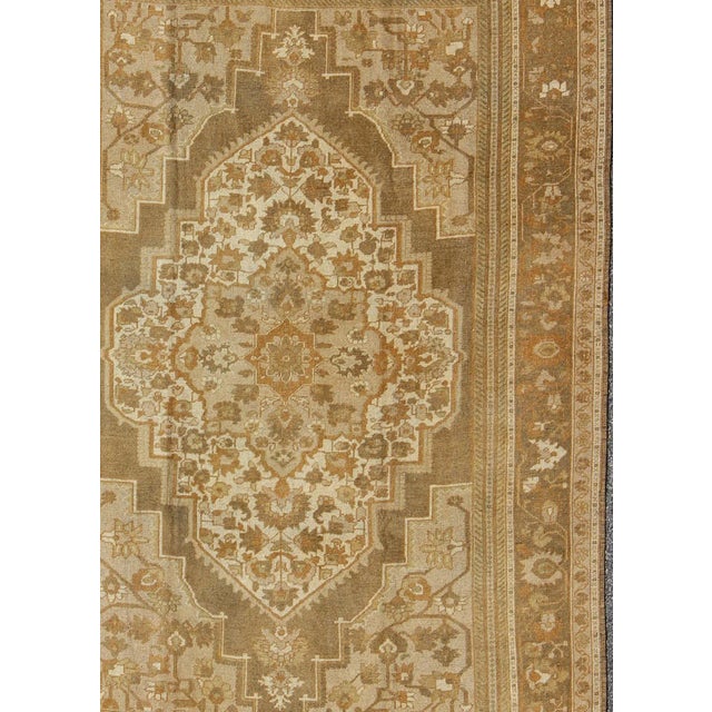 Measures 6'5 x 9'7 This vintage Turkish Oushak carpet, (circa mid-20th century) features a floral central medallion...