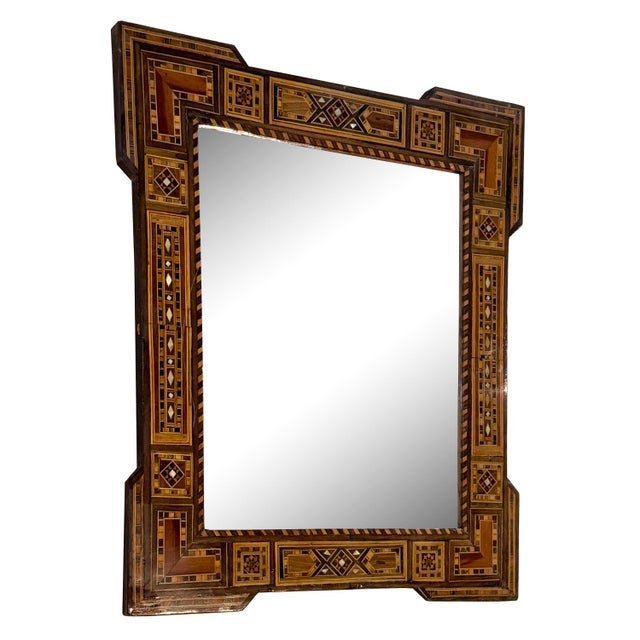A stunning example of early 20th-century craftsmanship, this mirror features natural wood inlaid with delicate mother-of-...