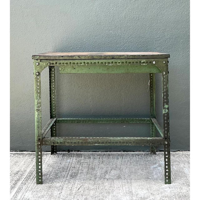 Constructed with heavy-duty slotted angle steel and topped with a weathered solid wood surface, this vintage industrial...