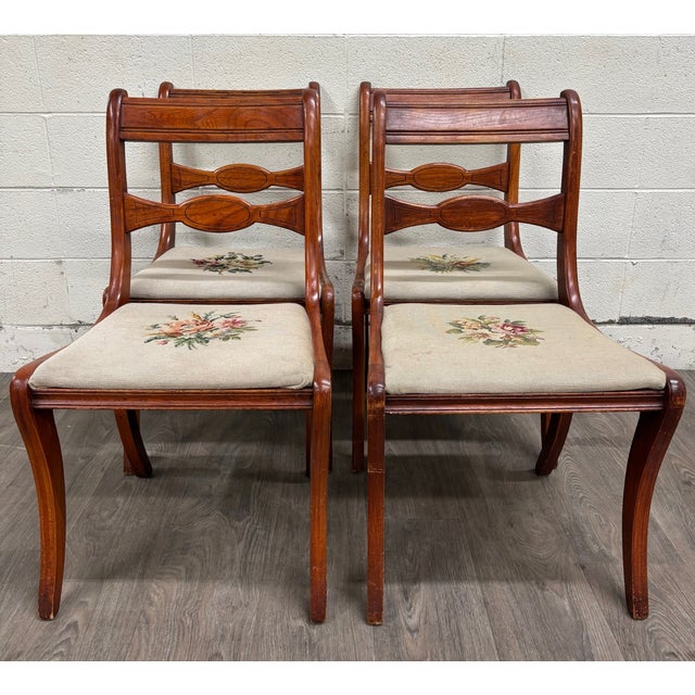 This is a beautiful antique full set of four Regency / Duncan Phyfe style dining chairs featuring elegant saber legs,...