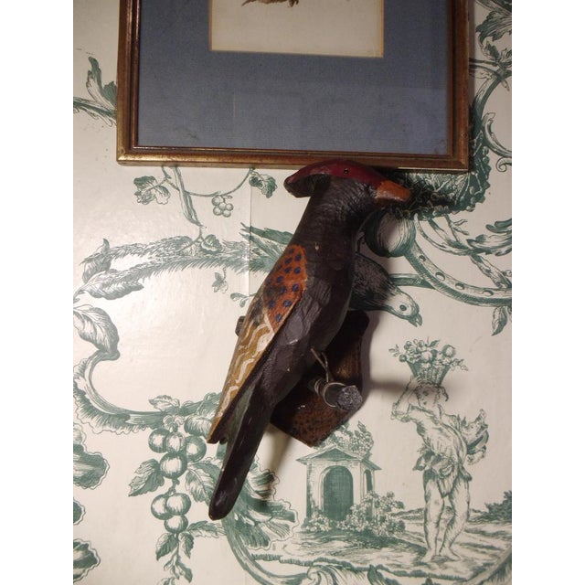 An antique, larger wooden bird with authentic patina and wall mount.