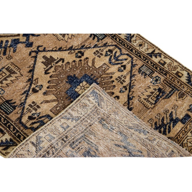 Beautiful Vintage Distressed hand-knotted wool rug with a brown field. This Persian rug has beige frame and blue accents...