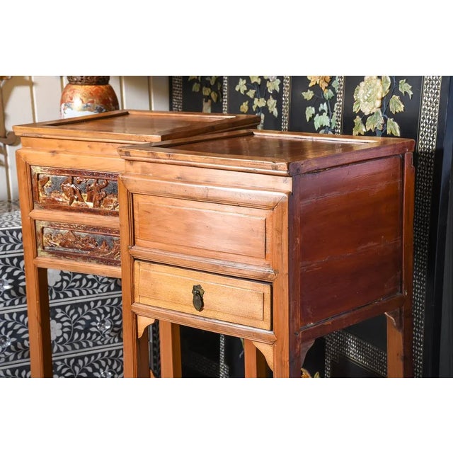 Pair of Oriental stands. One drawer on each. Carved scenic detail accents on two sides and a shelf below. Elm