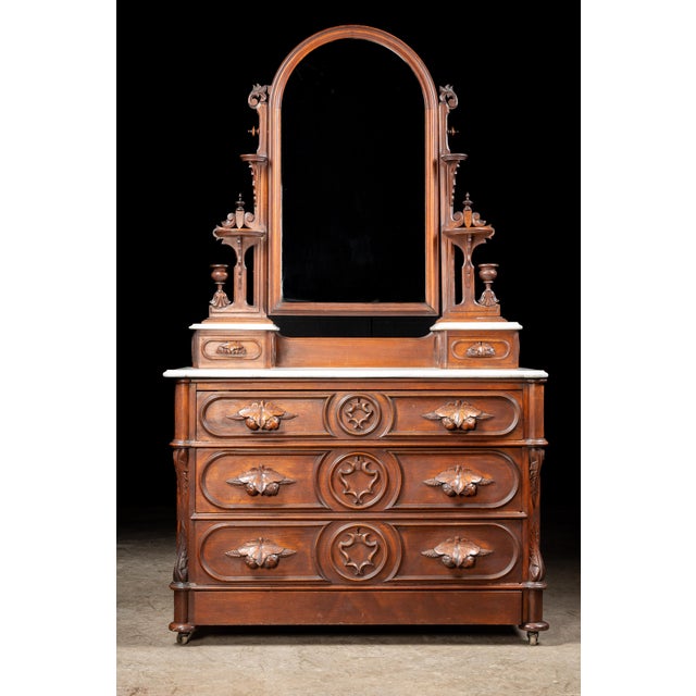 An elegant American Victorian dresser and mirror crafted from richly toned walnut. The dresser features a shapely marble...