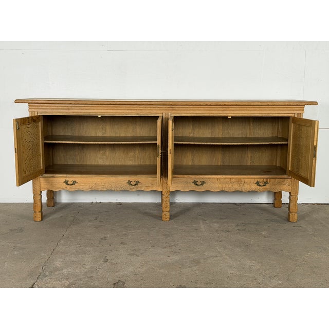 Danish sideboard in bleached solid oak, likely produced by a Danish cabinetmaker, 1960s. Four fielded doors open to two...