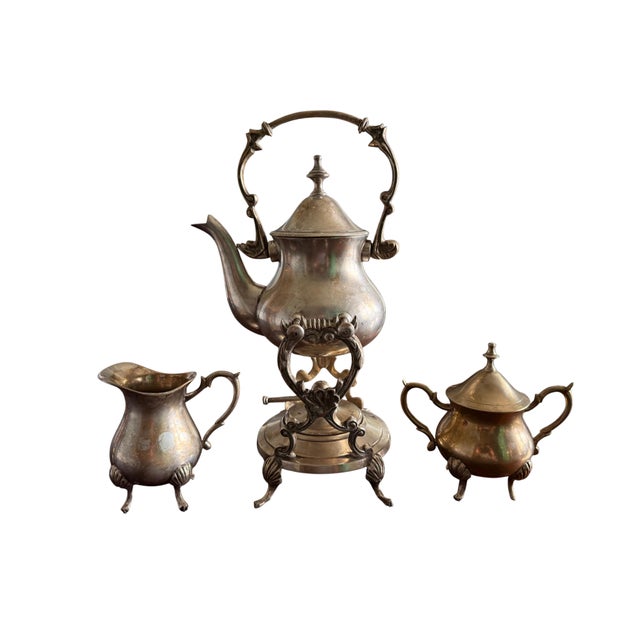 Distinctive vintage silverplate tilting tea set, made in India, including a handled teapot on stand, creamer, and lidded...