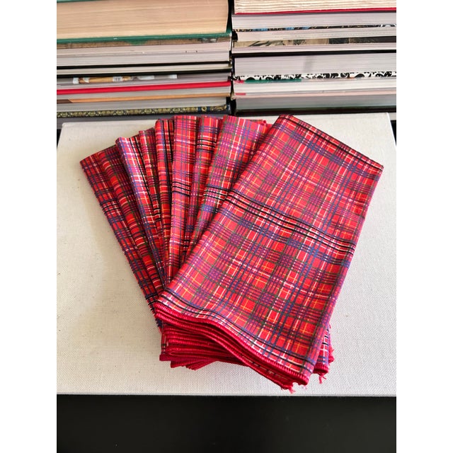Set of nine vintage plaid cloth napkins in a classic red tartan-style pattern with green, blue, black, and white accents....
