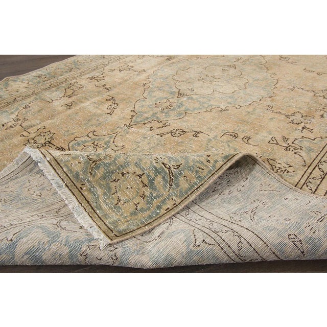 A hand-knotted Tabriz rug with a medallion design. This rug measures 5'10" x 9'5".