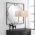 A Square Iron Frame Finished In Satin Black Surrounds A Suspended, Round Polished Edged Mirror, Held With Antique Gold...