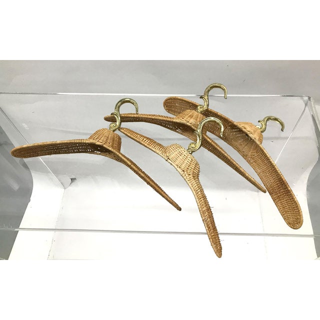 Set of 4 vintage rattan coat hangers with brass-finished hooks, circa 1970s. Probably originally a commercial display set...