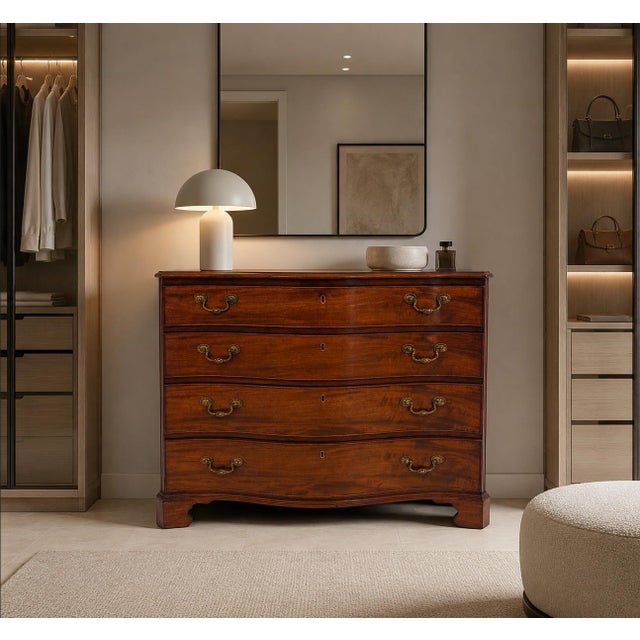 An antique 18th century Georgian mahogany serpentine chest of four drawers with an unusual and particularly elegant form,...