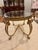 Beautiful, traditional-style oval coffee table featuring a thick, beveled glass top and an ornate gold-tone metal base....