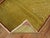 A vintage Turkish rug with a pea green field outlined with a thin red narrow border.