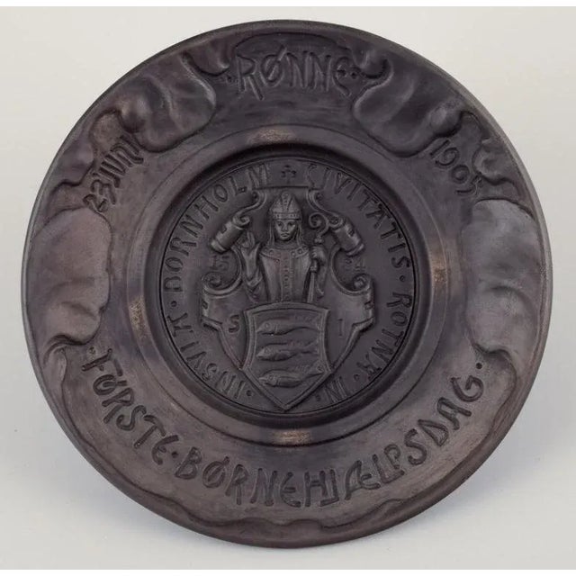 Hjorth, Bornholm. Wall relief and lidded jar in black terracotta. Wall relief title: "First Children's Aid Day Rønne 1905"...