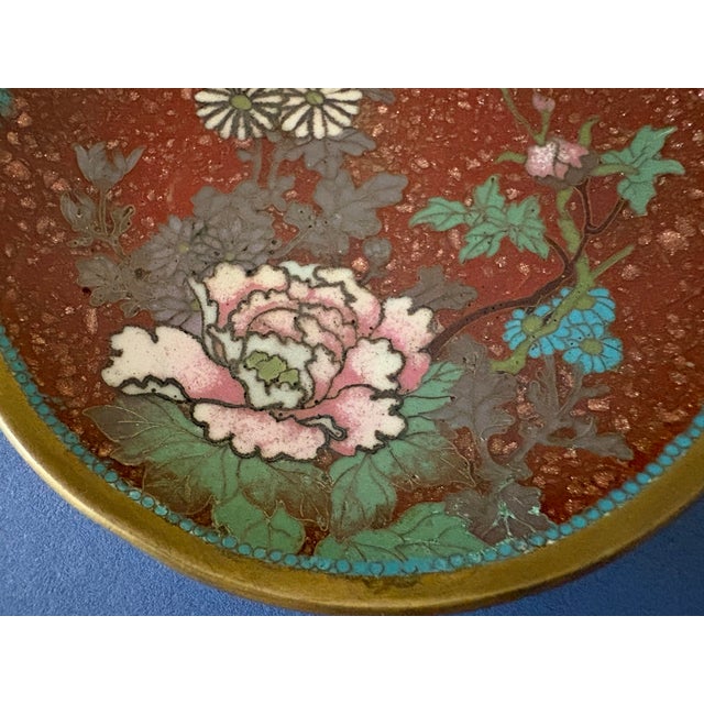This antique Chinese cloisonné dish features intricate enamel detailing in red of flowers. The vibrant multicolor design...