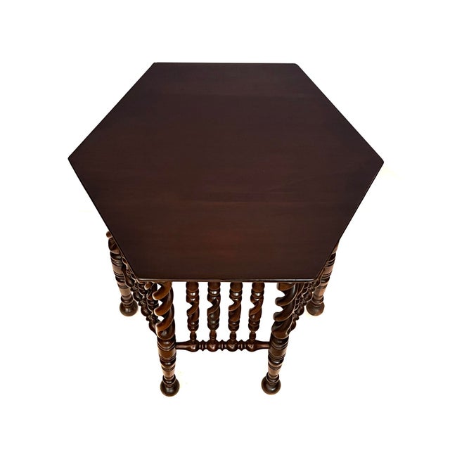 the deeply patinated occasional table with hexagonal top above an intricately carved openwork body of barley twist...