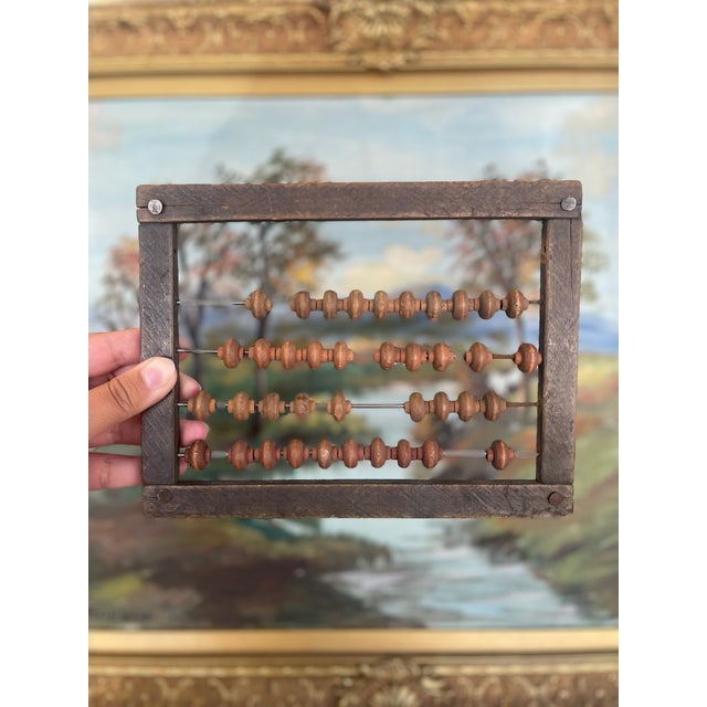 Estimated Early 20th-century wooden abacus with a dark hardwood frame and turned wooden beads strung on metal rods. This...