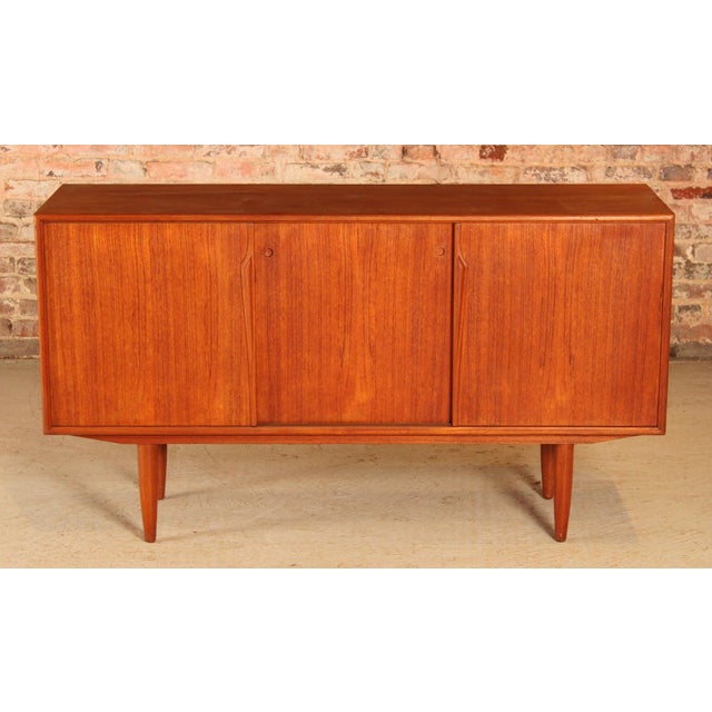 Danish Mid Century teak sideboard by Axel Christensen for Aco Mobler, circa 1960s. Three sliding doors, one felt lined...