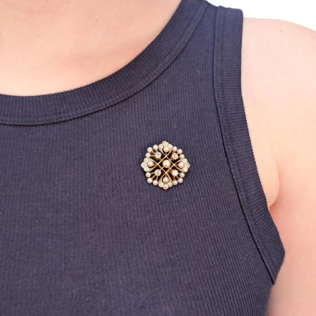 A fine antique gold, pearl, and diamond convertible brooch or pendant. In 14 karat yellow gold. Set with 17 pearls and 16...