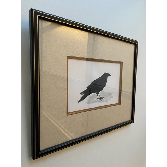 This is an original black crow watercolor painting with an elevated woven mat in a black and gold frame signed R.D.