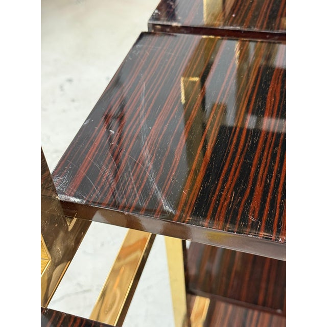 A beautiful room divider or book case in brass with macassar ebony veneered wood base and shelves. The Demi lune shaped...