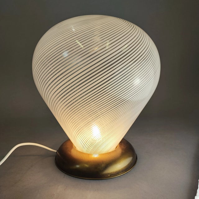 Table lamp in half filigree blown glass and brass base. Also available with brass attachment to transform it into a...