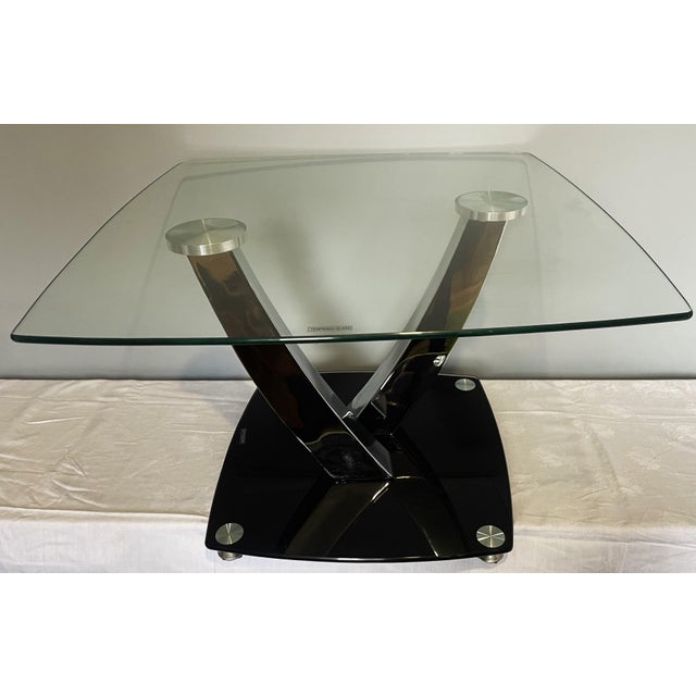 A stylish table with a unique, designer shape – curved chrome-plated support elements and a tempered glass top give it a...