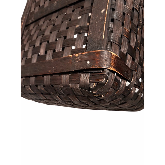 A beautifully crafted vintage three-piece nesting basket set featuring a rich, dark-stained woven rattan construction....